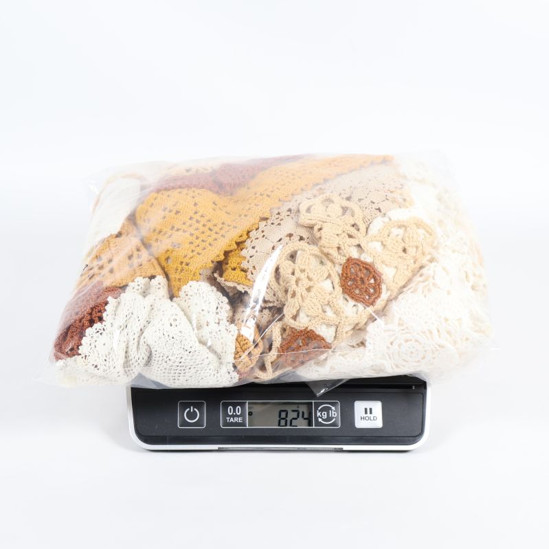 Påse med virkade dukar vägd på våg, vikt synlig