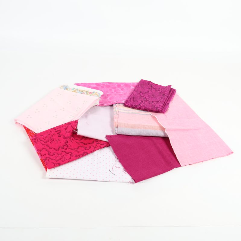 Bunt av rosa och lila tygbitar i olika mönster