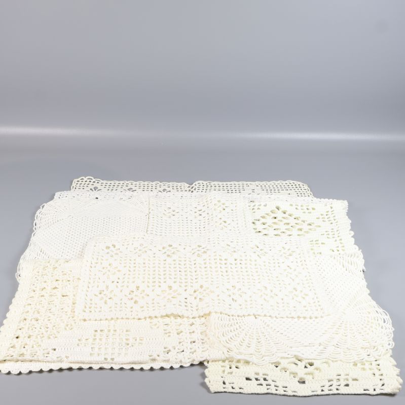 Flera virkade dukar utlagda med synligt virkningsarbete