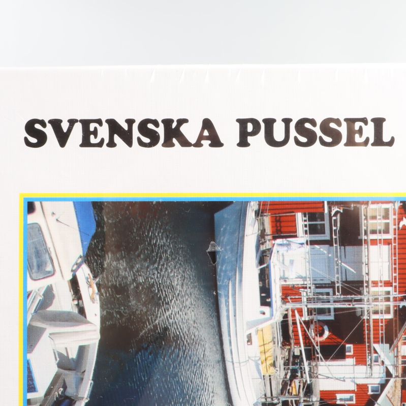 Närbild på texten Svenska Pussel på boxen