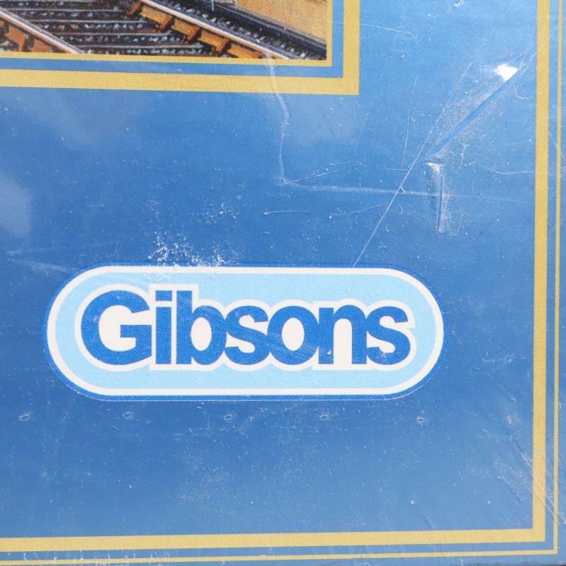 Närbild på Gibsons logotyp på pussellådan