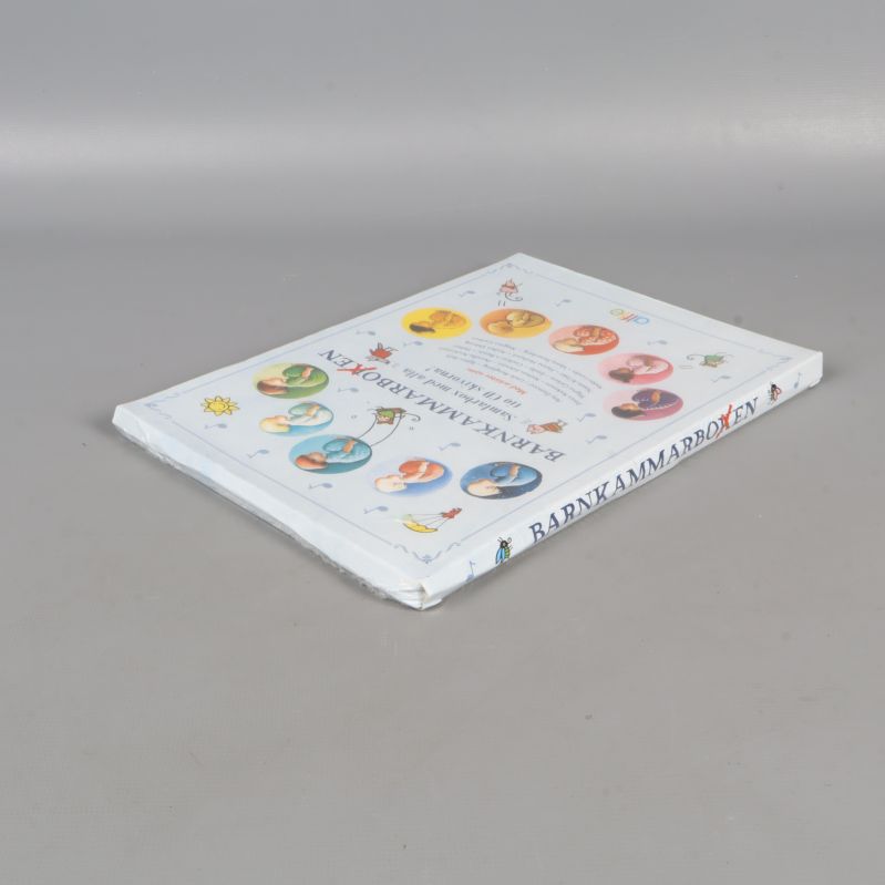 Barnkammarboken box i plastskydd från vinkel höger bak