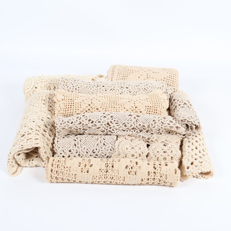 Flera vikta virkade spetsdukar i beige toner