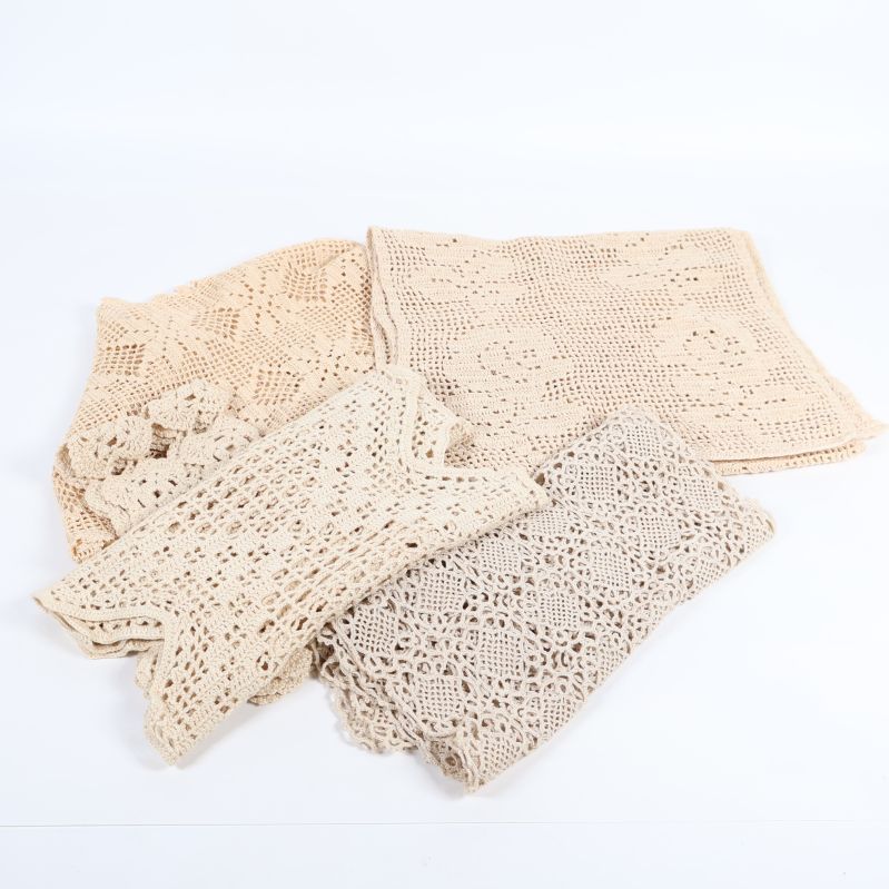 Fyra virkade spetsdukar utlagda i olika storlekar