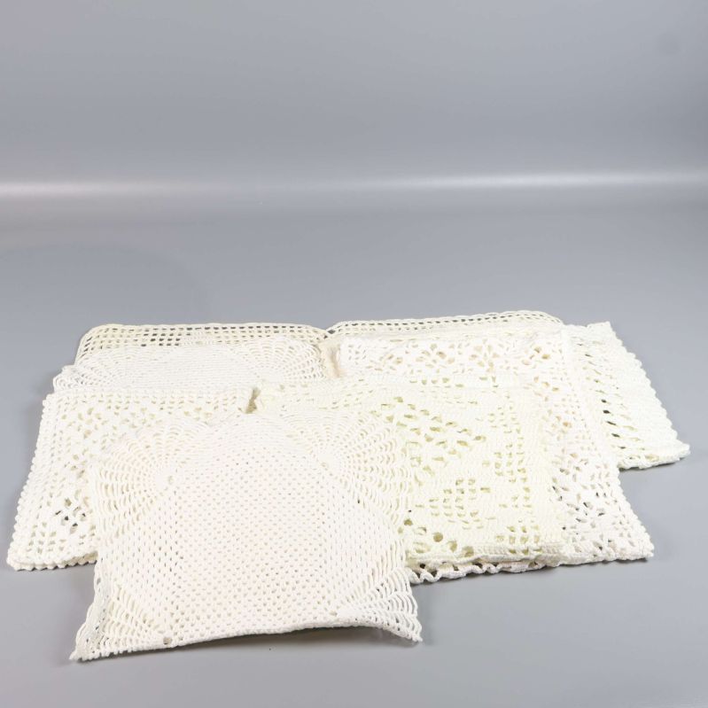 Flera utlagda fyrkantiga virkade dukar syns framifrån