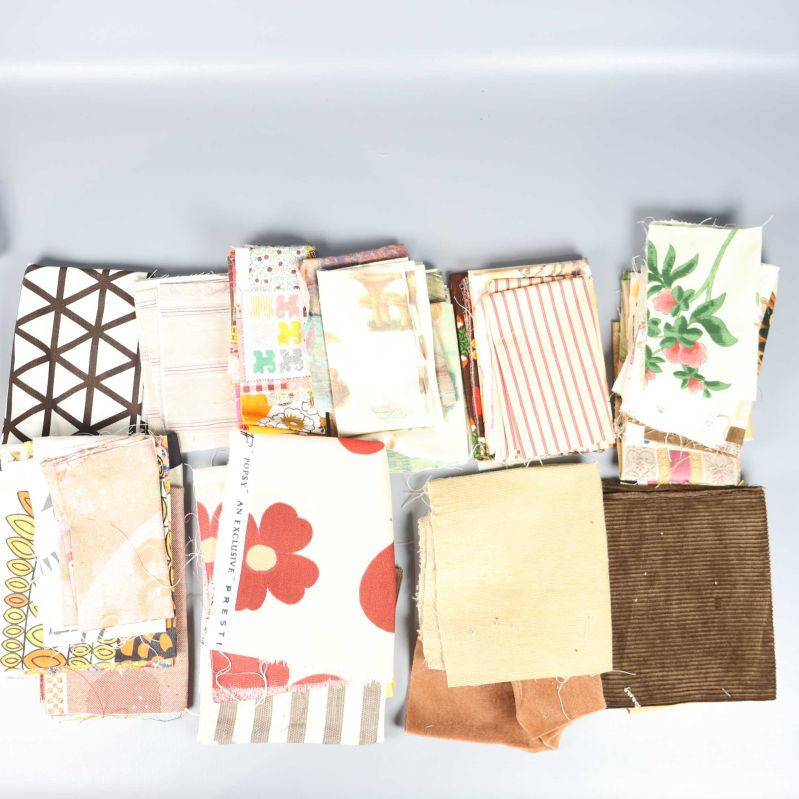 Färgglada tygbitar med olika mönster och storlekar uppdelade i högar