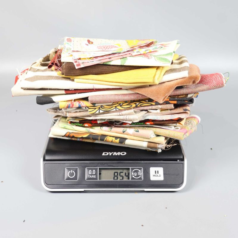 Tygbitar vägs på våg, vikt 854 gram visas