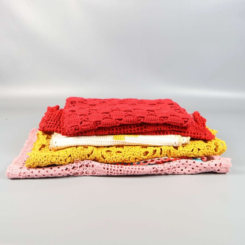 Staplade virkade dukar sedda från sidan mot grå bakgrund