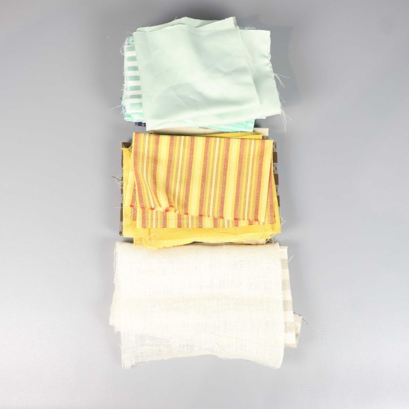 Tygbuntar i stapel med randiga, pastellfärgade och gula tyger