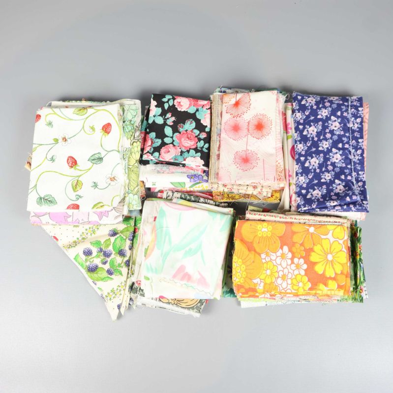 Vikta färgglada tygbitar med blommönster på grå bakgrund