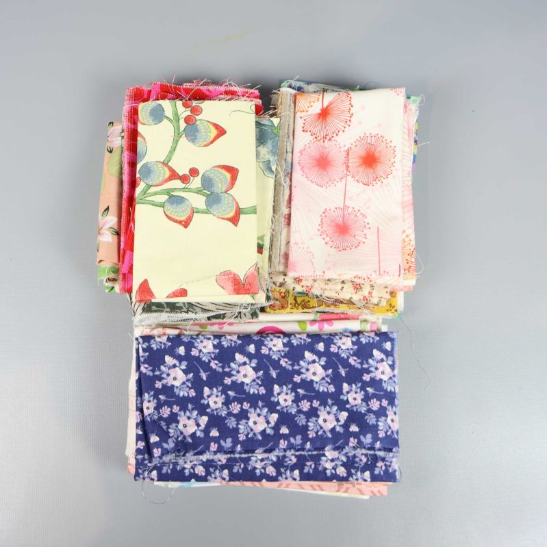 Närbild på tygbitar med blommor och växtmotiv