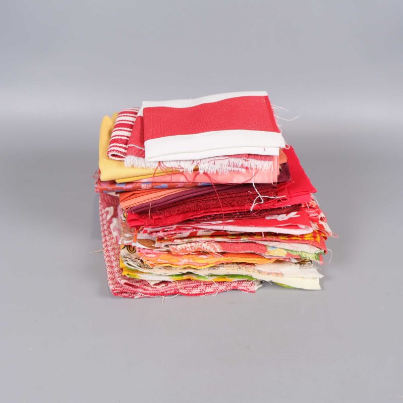 Stapel med blandade tygbitar i rött, gult och vitt