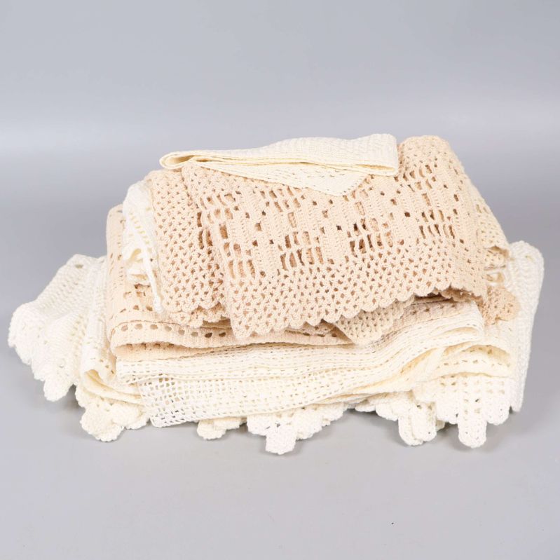Hög med virkade spetsdukar i beige och vitt