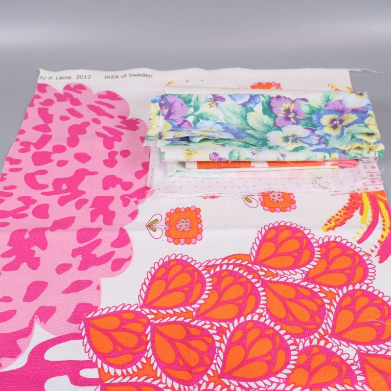 Stora och små tygbitar med rosa, orange och blommiga motiv