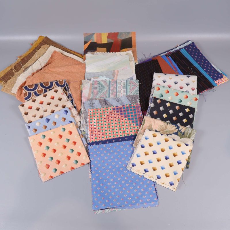 Stort urval av färgglada tygprover i olika mönster samlade på rad