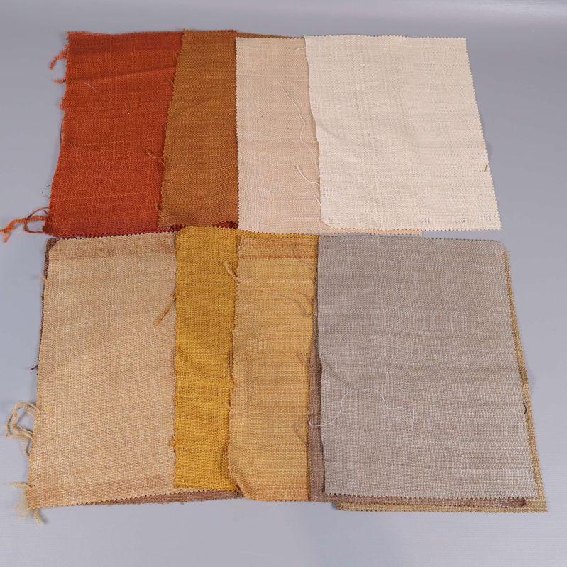 Åtta tygprover i jordnära nyanser som orange, beige och gult