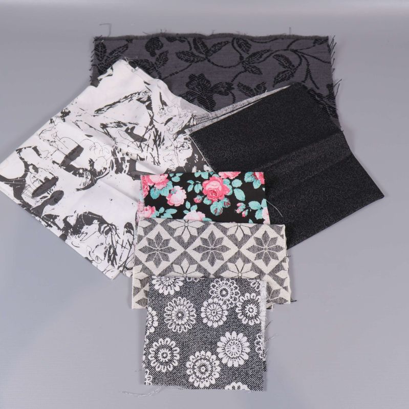 Svartvita och blommiga tygbitar ordnade i grupp