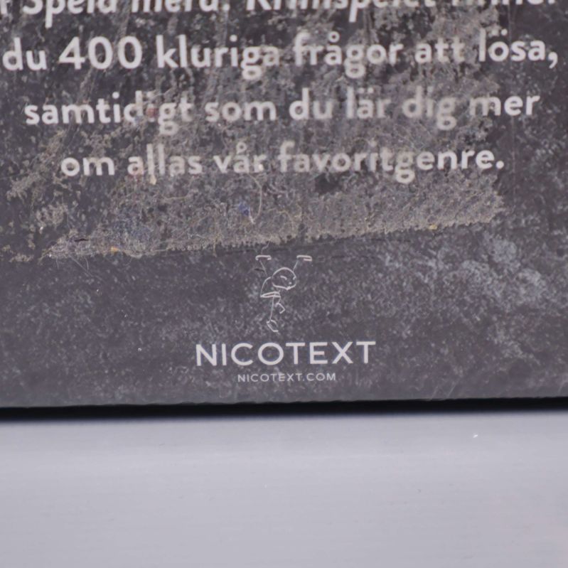Närbild av baksidan med Nicotext-logotyp på Krimspelet