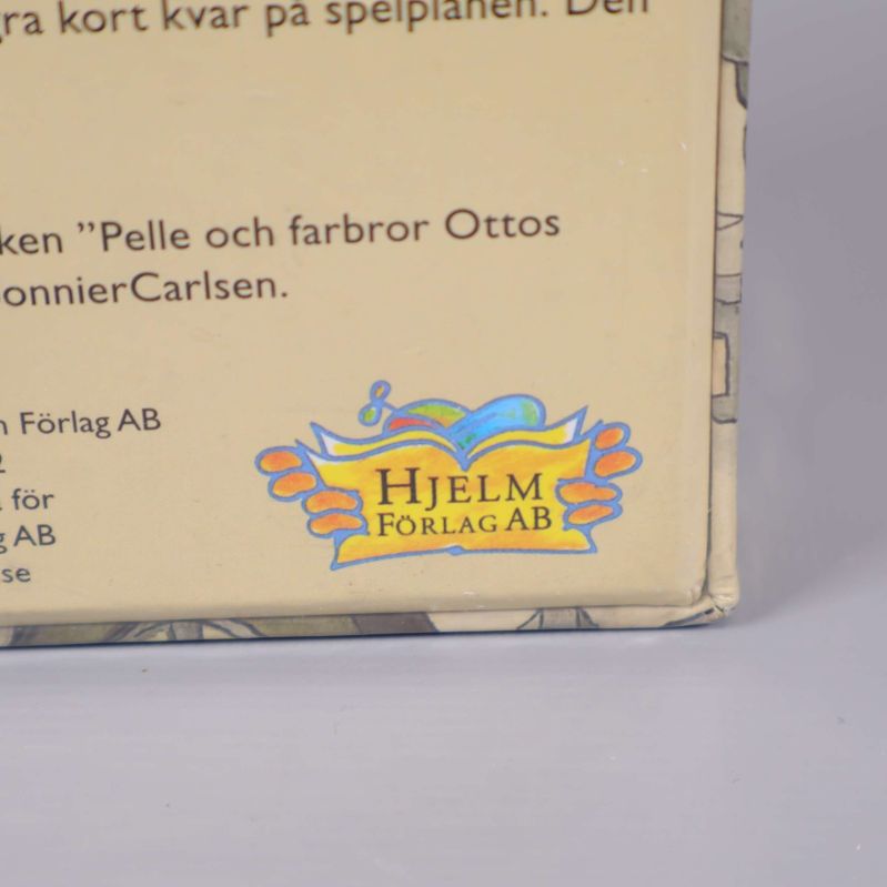 Närbild på Hjelm Förlag AB:s logotyp på lådan