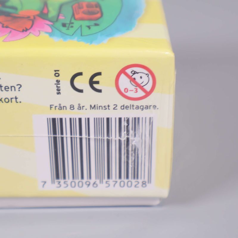 Närbild på åldersrekommendation och streckkod på Sommar Semesterspelet