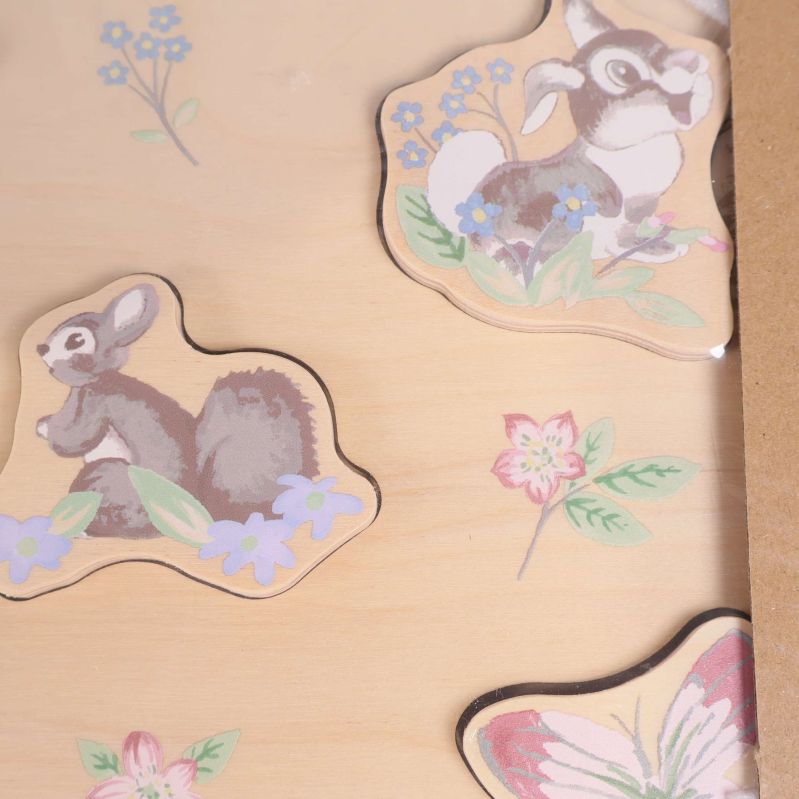 Närbild på två bitar från babypusslet med blommotiv