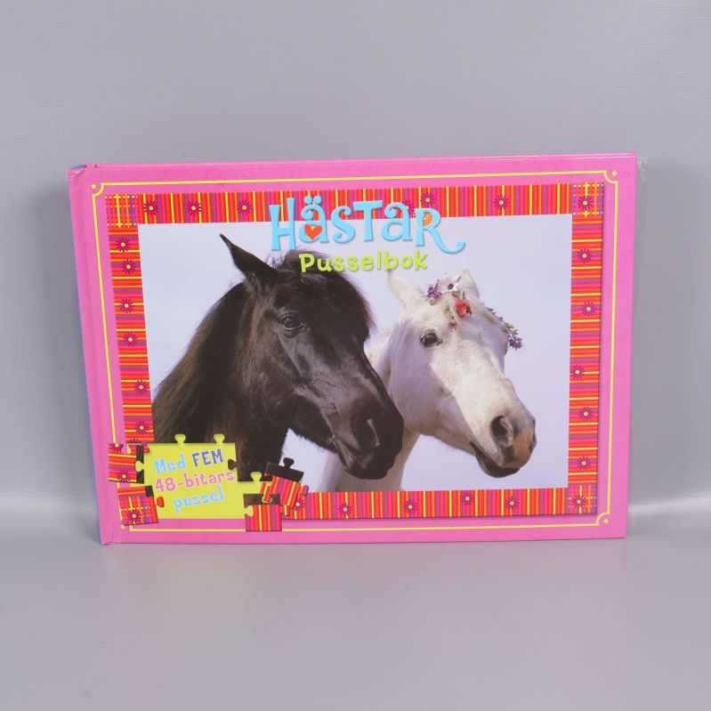 Förpackad pusselbok med hästmotiv framför grå bakgrund