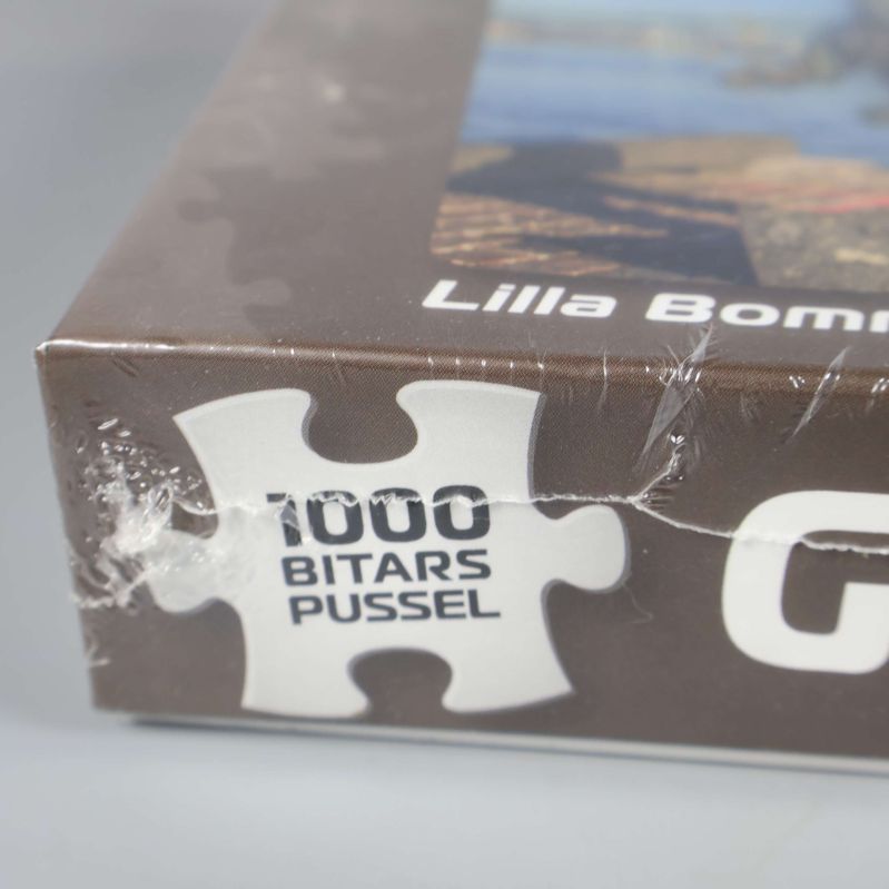 Närbild av pussellåda med texten 1000 bitars pussel tryckt på sidan