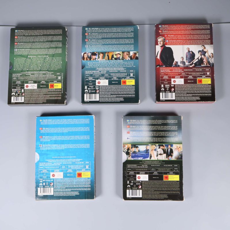 Baksidor av NCIS DVD-boxar med texter och bilder