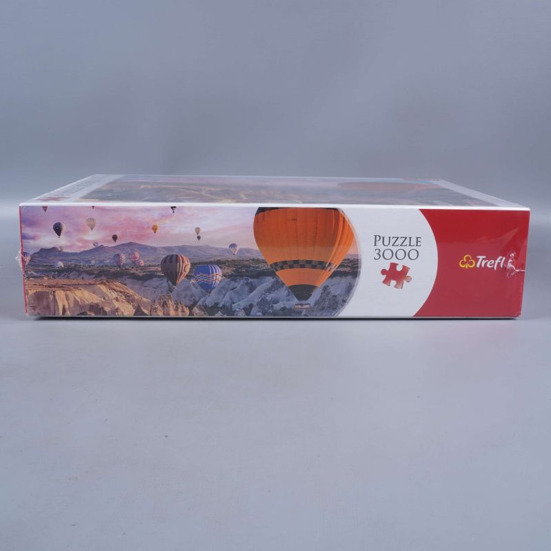 Sidan på pusselask med motiv av luftballonger och Trefl logotyp