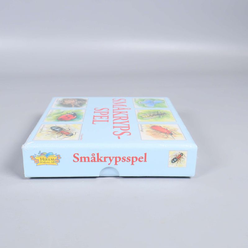 Sida av kartongen med småkrypsspelets namn i rött