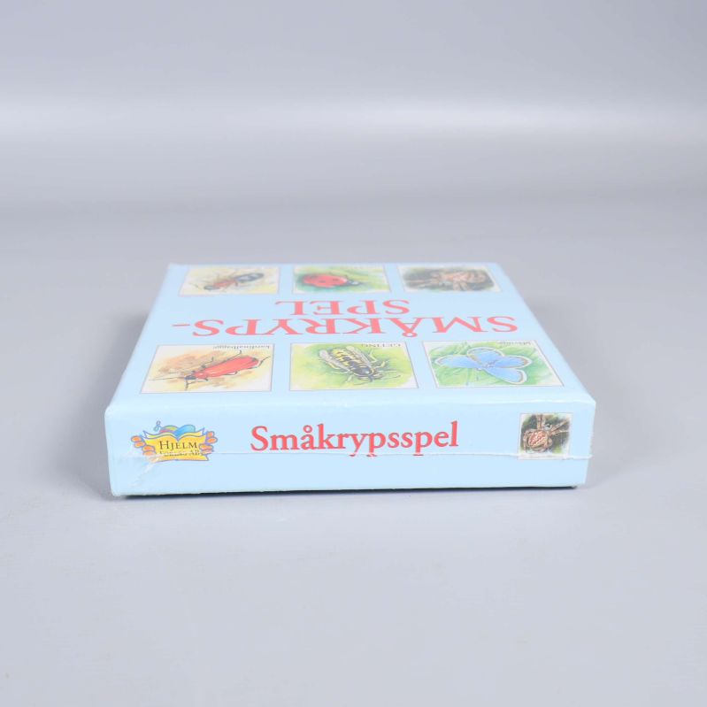 Smal sida av kartong med småkrypsspelets titel och insekt