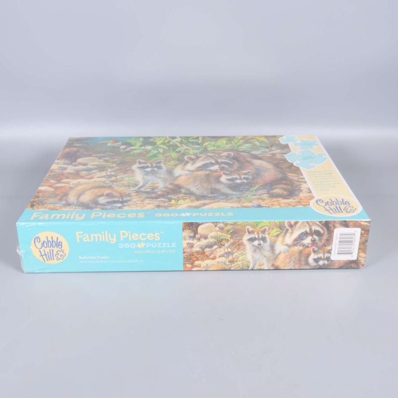 Sidan av lådan med pusslets namn och illustration av tvättbjörnar