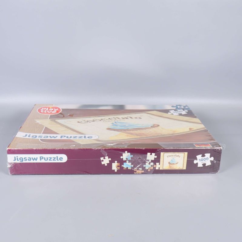 Sidan av pussellådan med texten Jigsaw Puzzle och cupcake-motiv