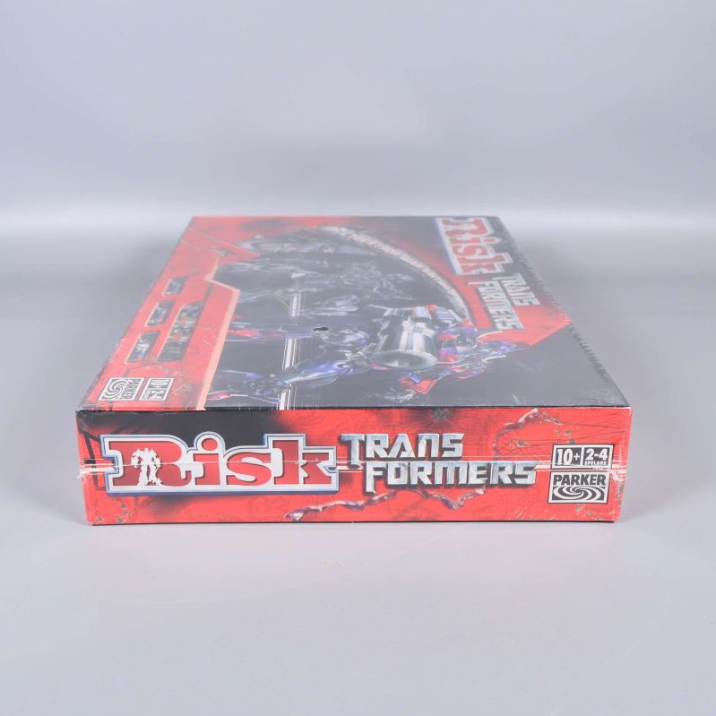 Kortsida av Risk Transformers med titel och åldersmärkning