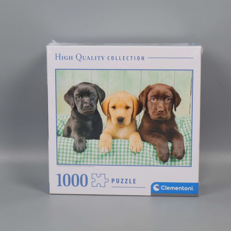 Framsidan av pussellåda med tre labradorvalpar