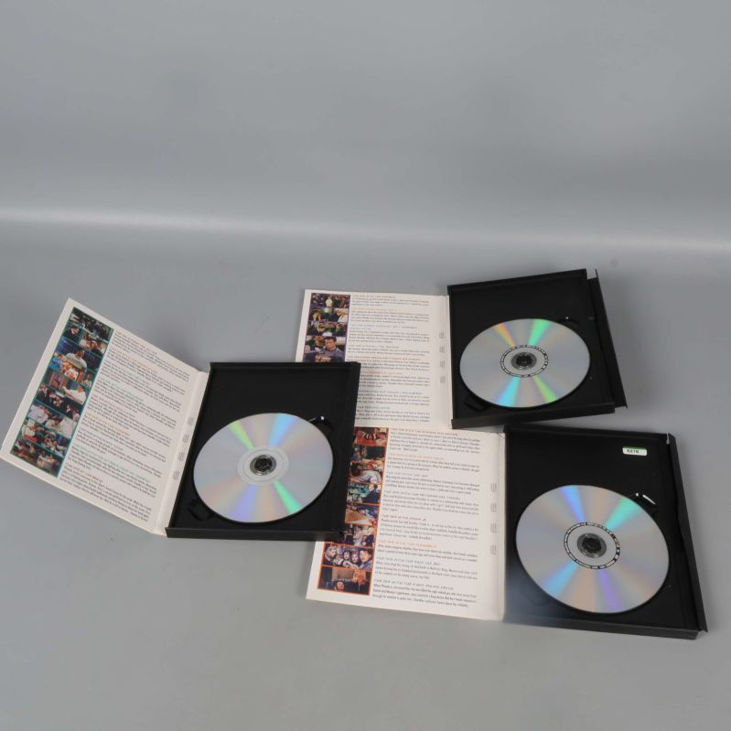 Öppnade DVD-fodral med skivor och avsnittsguide