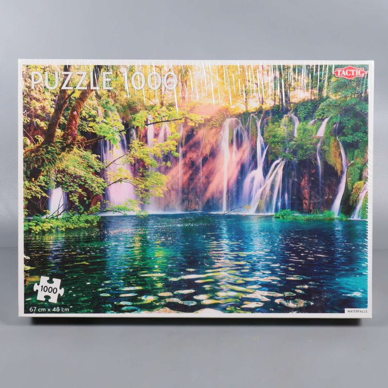 Framsidan av pussellåda med vattenfall och grönt landskap