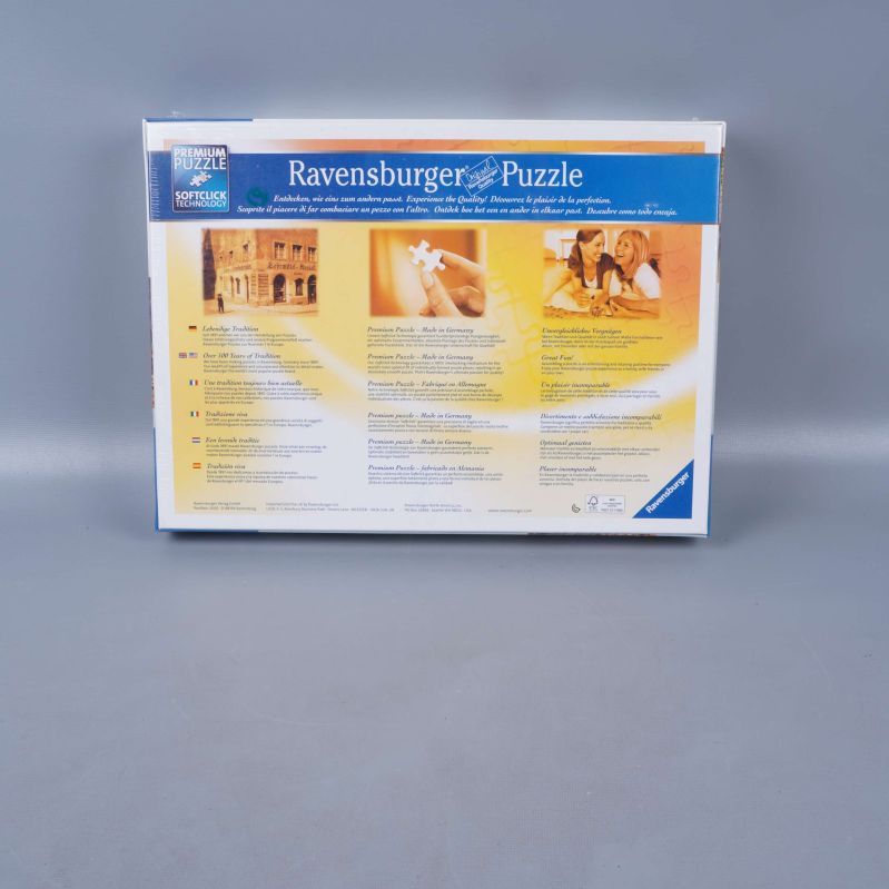 Baksida av Ravensburger pusselbox med text och bilder