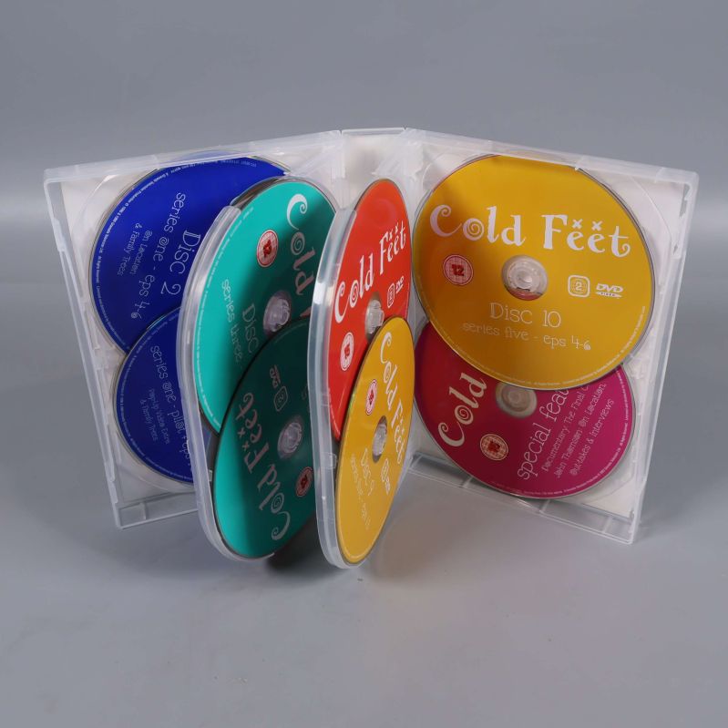 Öppnad DVD-box med flera färgglada skivor av Cold Feet