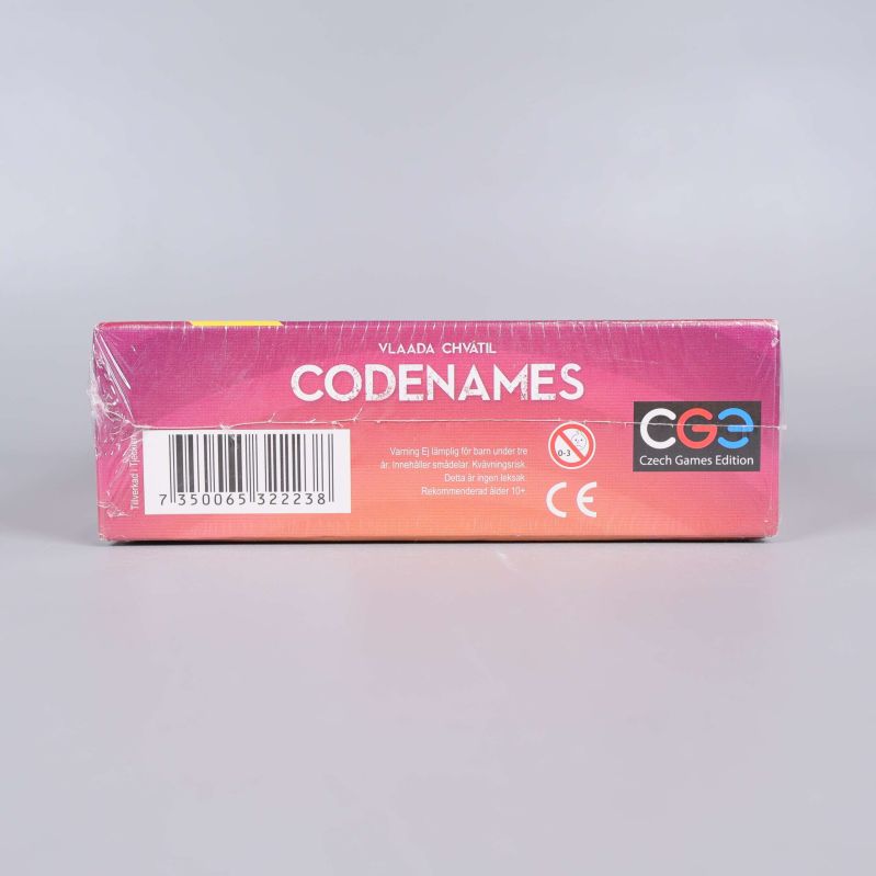 Kortsida på Codenames spelkartong med streckkod och logga