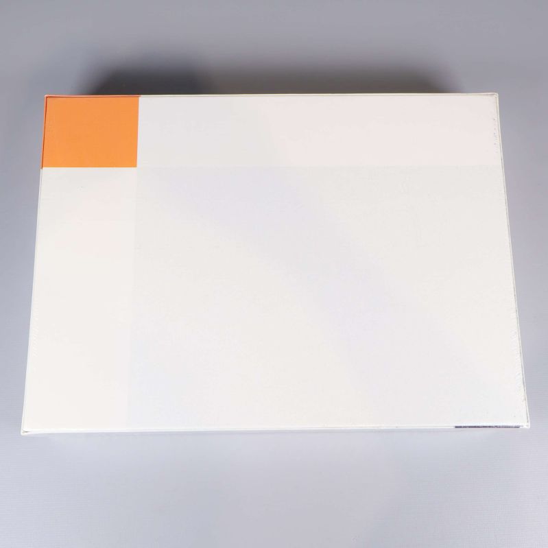 Baksida på pusselkartong, helt vit med orange hörn