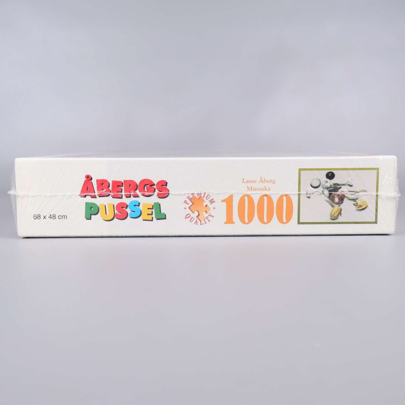 Sida av kartong med Åbergs pussel logotyp och 1000 bitar