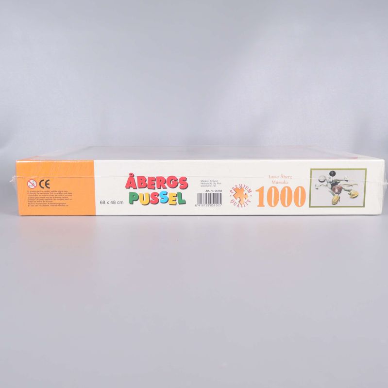 Sida av box med Åbergs pussel text och information