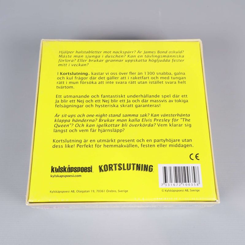 Baksida av spelboxen Kortslutning med gul bakgrund och beskrivande text