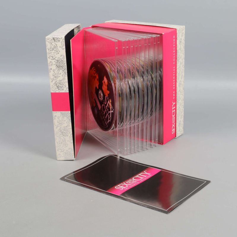 Boxen öppen med 12 dvd-skivor och häfte synliga