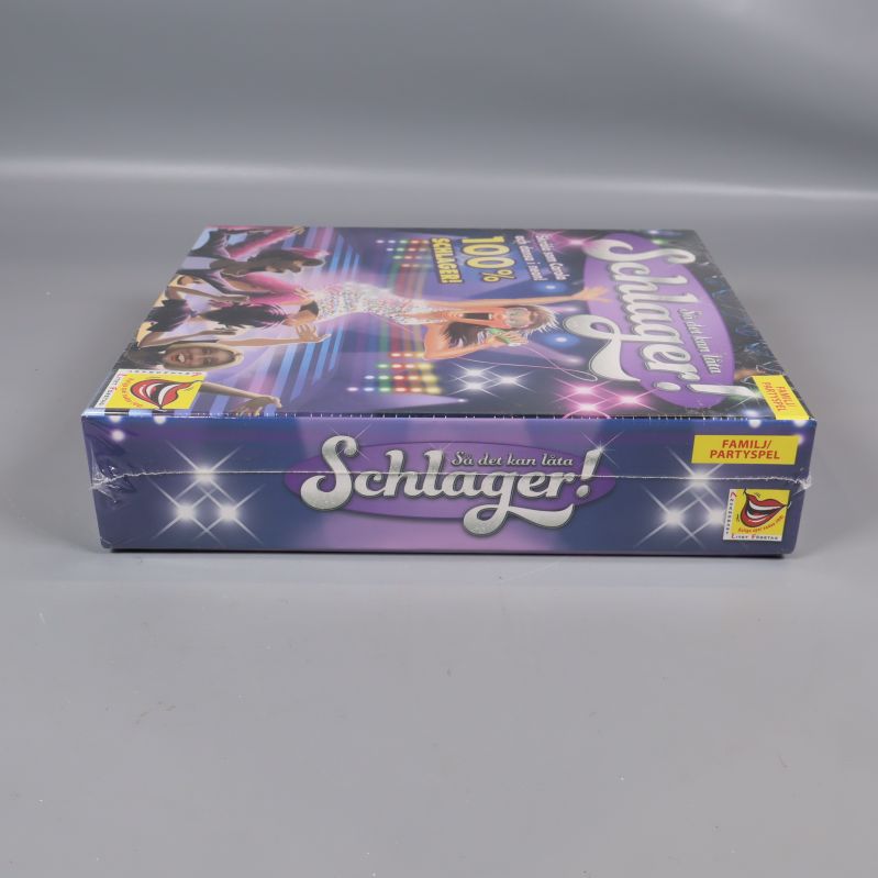Schlager spelkartong sedd från andra sidan med text och logga