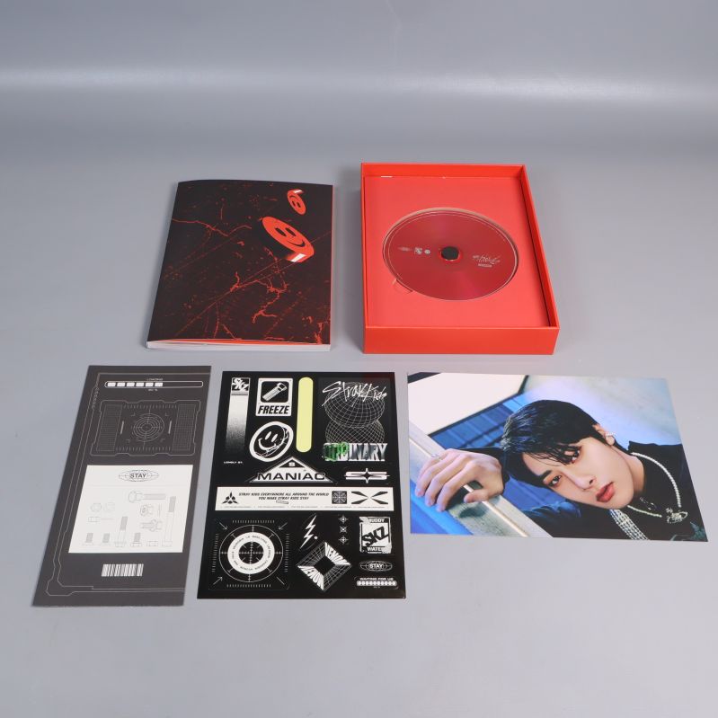 Innehåll i röd Oddinary-albumask; CD, fotobok, fotokort, stickers