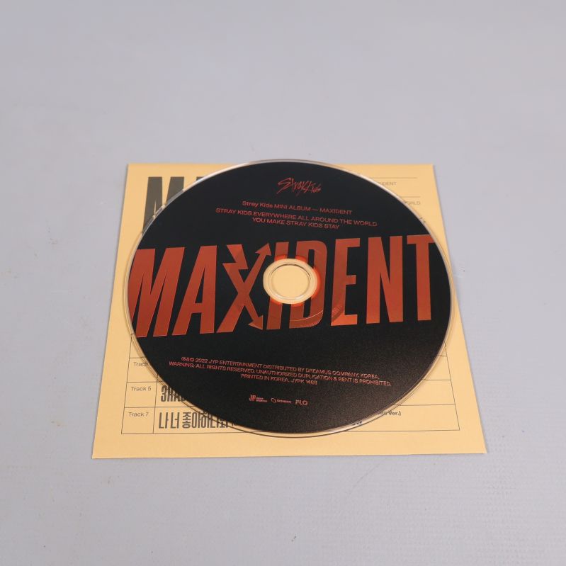 CD-skiva med Maxident-tryck placerad på ett gult ark