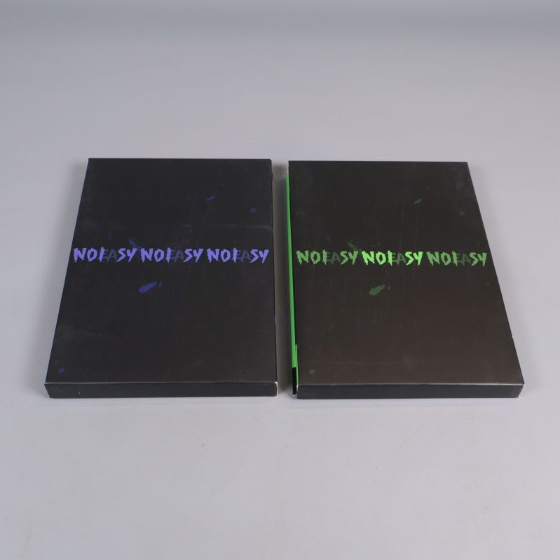 Två kpop album i svart med färgstark text på omslaget