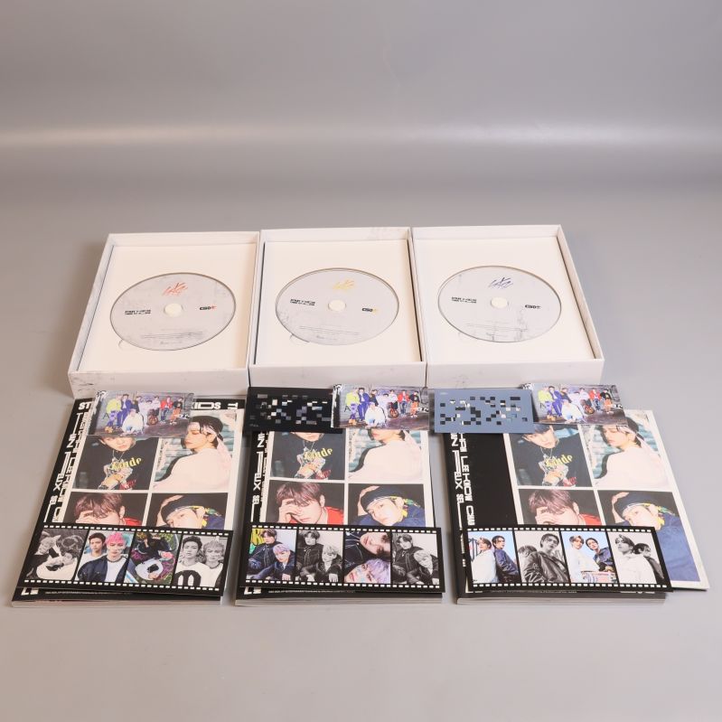 Stray kids album öppnade med cd-skivor, fotoböcker och kort synliga